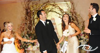 Ryan & Celena laughing during the personalized Grand Entrance introductions of their Wedding Party members delivered by their Wedding Entertainment Director®, Peter Merry with MERRY WEDDINGS, at the Surf & Sand Hotel in Laguna Beach, CA. (Photo Credit: Jim Kennedy Photographers)